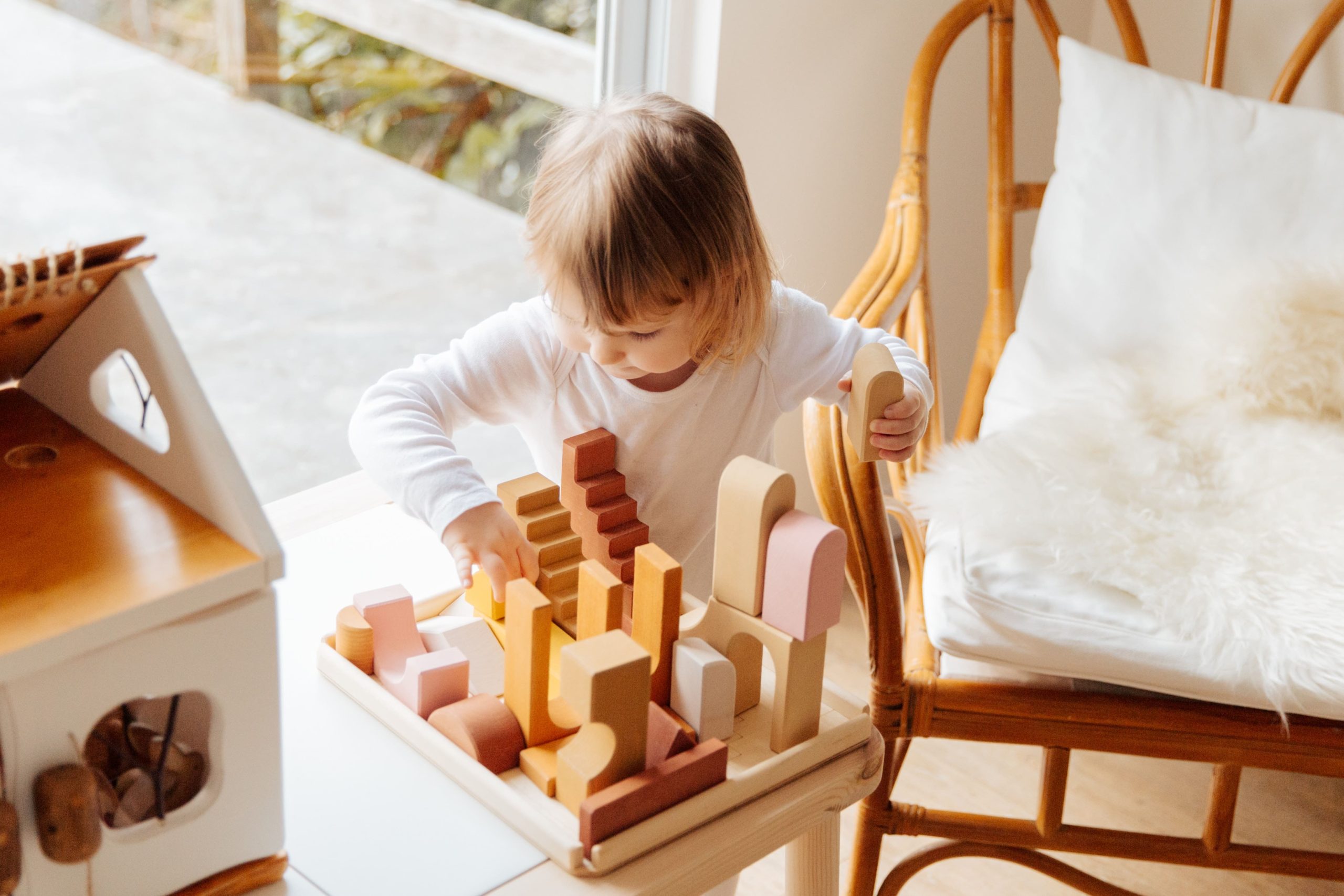 تصویر کودک در حال بازی با اسباب بازی چوبی 